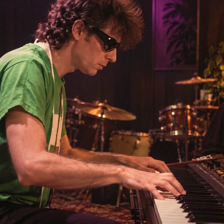 Dr. Fink playing a keyboard in a studio